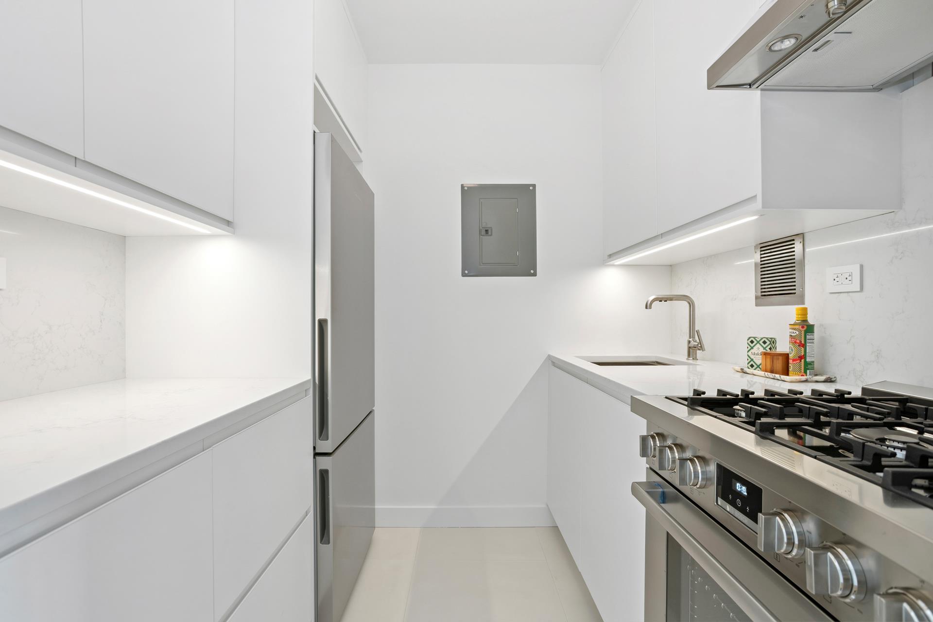 45 West 67th Street, Unit 25F Manhattan, NY 10023 - Photo 3 of 9 a kitchen with a stove and a refrigerator