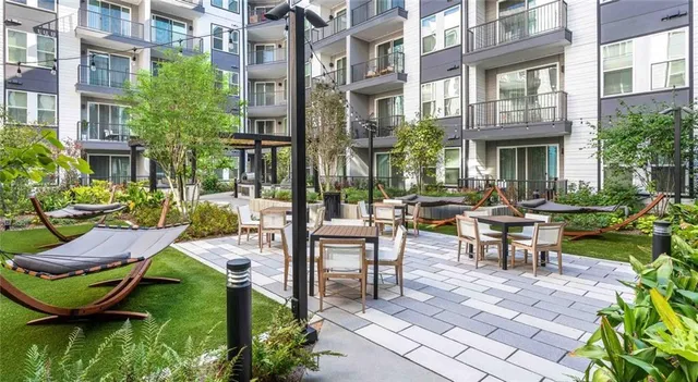 a living room with patio furniture and a potted plant