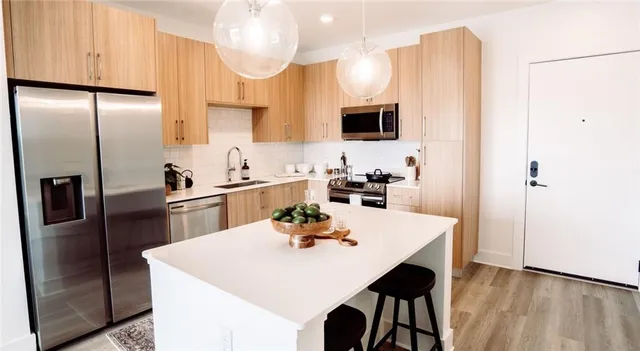 a kitchen with stainless steel appliances a table chairs and refrigerator