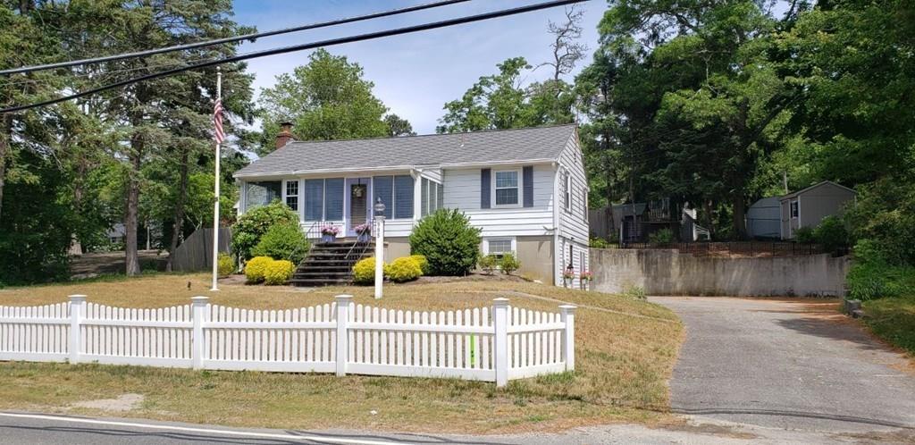 985 Shore Road Bourne, MA 02559 - Photo 1 of 27 a view of a house with a small yard and wooden fence