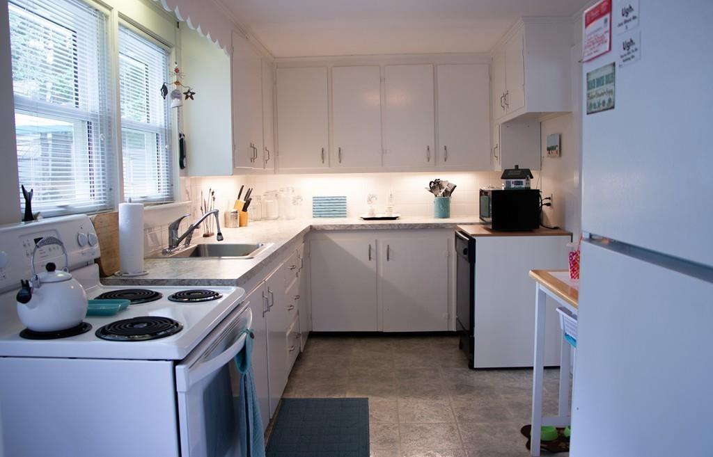 985 Shore Road Bourne, MA 02559 - Photo 9 of 27 a kitchen with a sink stove and cabinets