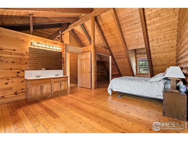 a bedroom with a bed and a wooden floor