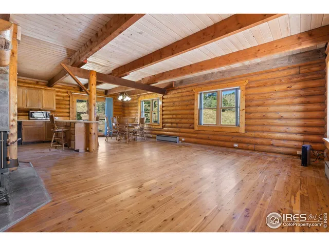 a kitchen with stainless steel appliances kitchen island granite countertop a table chairs in it and wooden floors