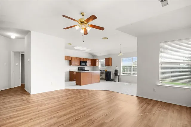 a view of a livingroom with furniture hardwood floor and a ceiling fan