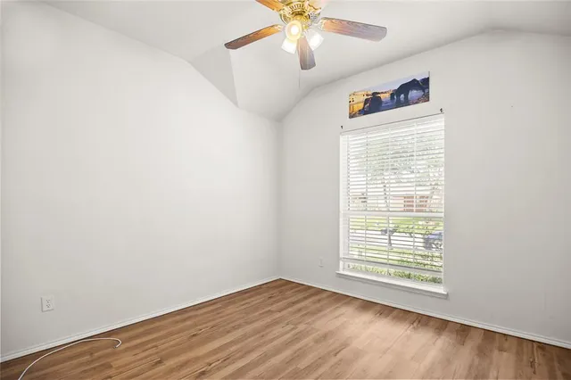 an empty room with a window and a fan
