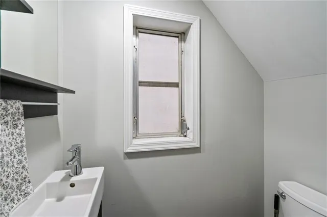 a bathroom with a sink a mirror and a toilet