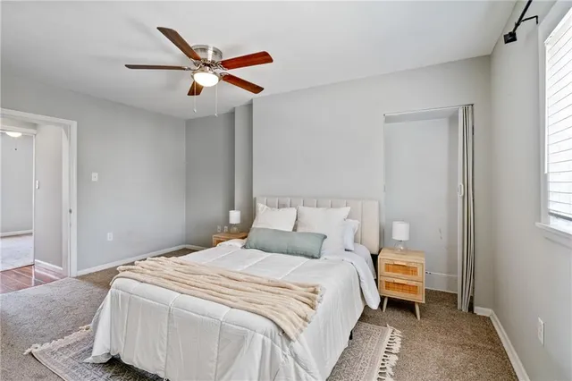 a bedroom with a large bed and a ceiling fan