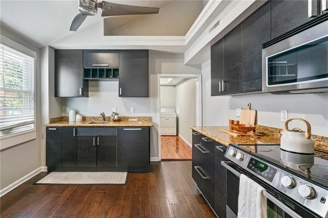 a kitchen with stainless steel appliances granite countertop a stove a sink and a microwave