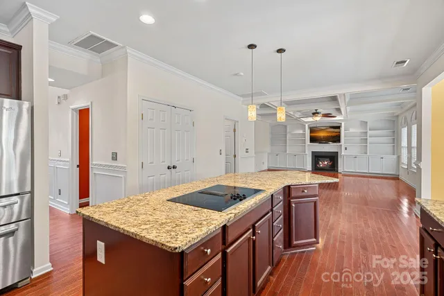 a kitchen that has a kitchen island wooden cabinets and stainless steel appliances