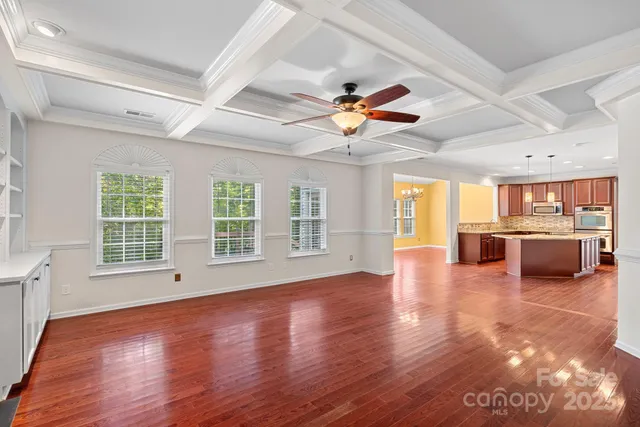 a view of a livingroom with furniture a ceiling fan and wooden floor