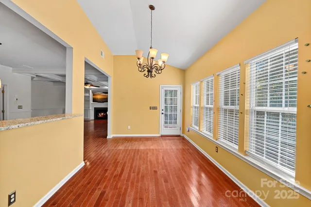 a view of a big room with wooden floor and windows