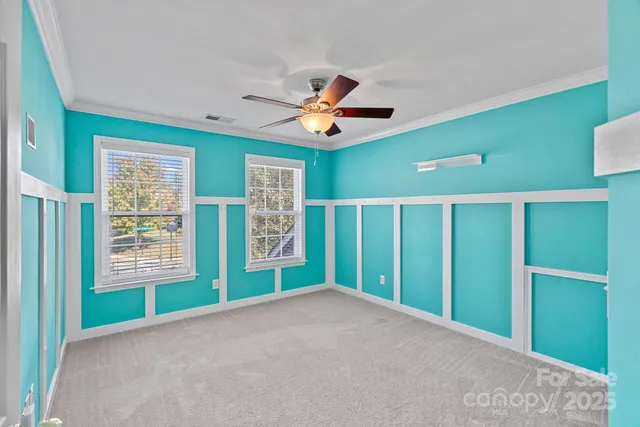 a view of an empty room with a window and a ceiling fan