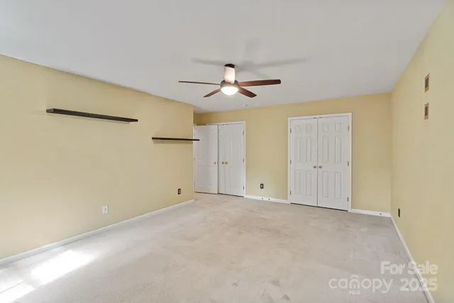 a view of an empty room with a ceiling fan
