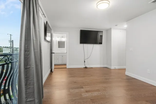 a view of a livingroom with wooden floor and a flat screen tv