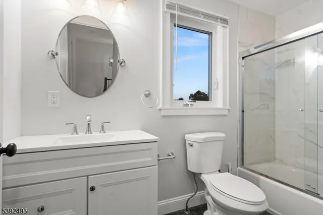 a bathroom with a toilet a sink and a mirror
