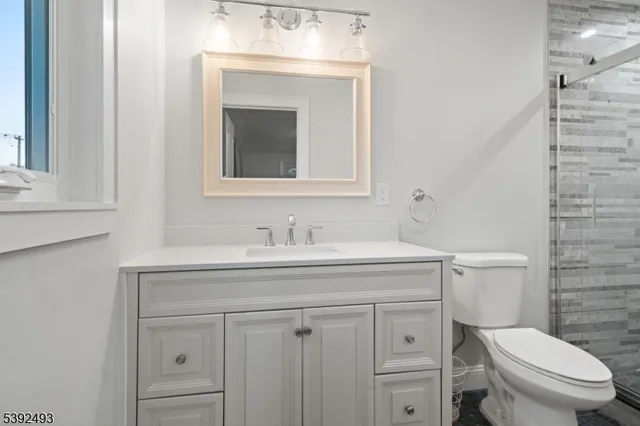 a bathroom with a toilet sink vanity and mirror