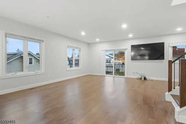 a view of a livingroom with furniture a flat screen tv and wooden floor