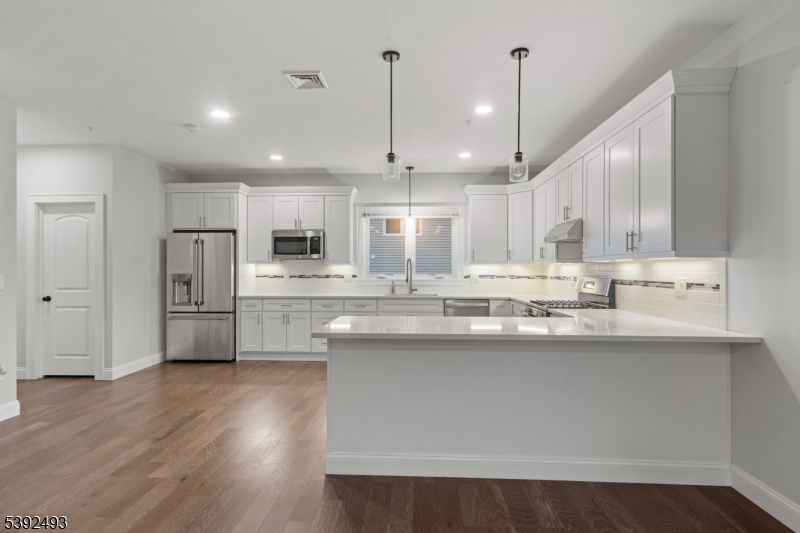 22 Arcadia Place Union, NJ 07088 - Photo 7 of 33 a kitchen with stainless steel appliances granite countertop a sink refrigerator and a wooden cabinets