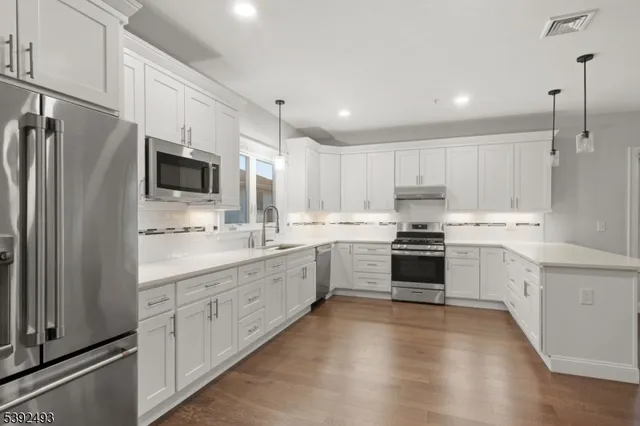 a kitchen with granite countertop white cabinets and stainless steel appliances