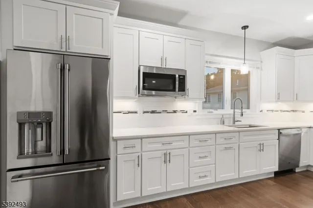 a kitchen with stainless steel appliances white cabinets and a sink