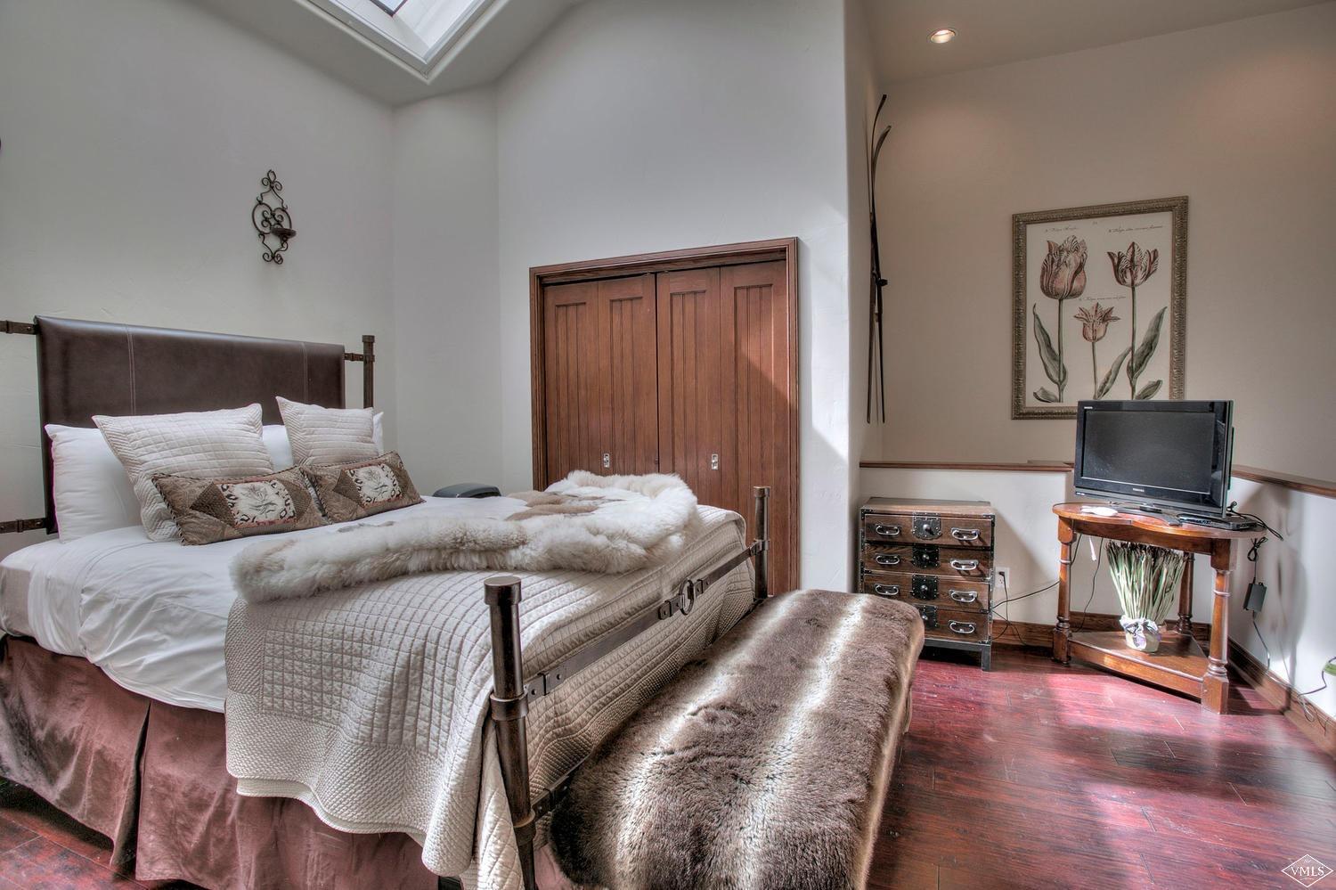 141 Scott Hill Road, Unit 402 Beaver Creek, CO 81620 - Photo 11 of 23 a bedroom with a bed and wooden floor