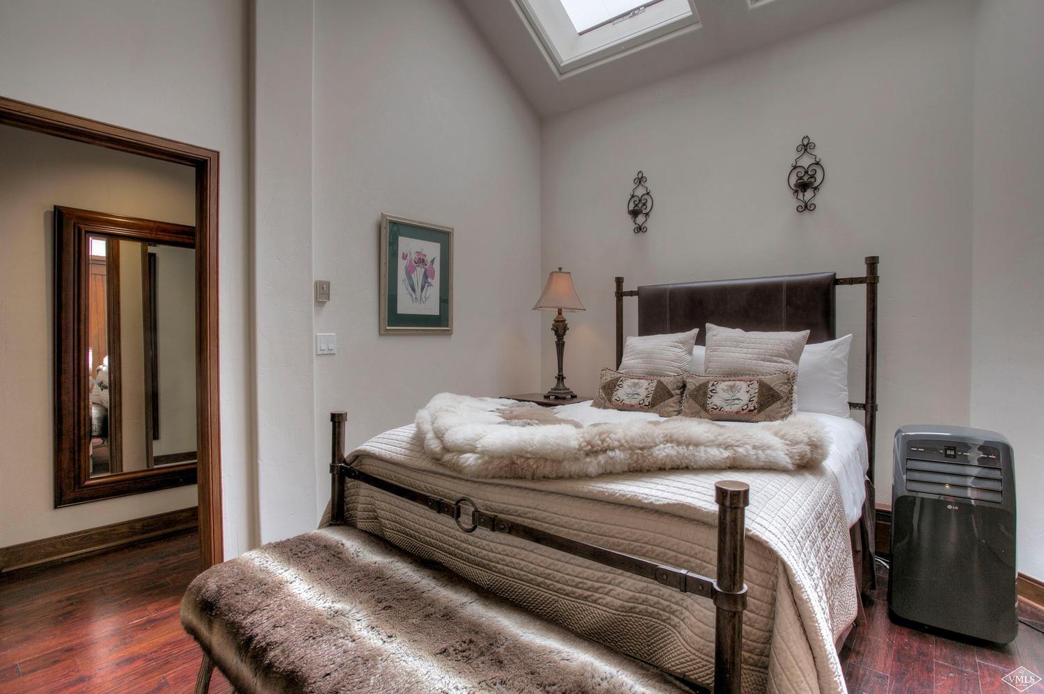 141 Scott Hill Road, Unit 402 Beaver Creek, CO 81620 - Photo 12 of 23 a bedroom with a bed and wooden floor