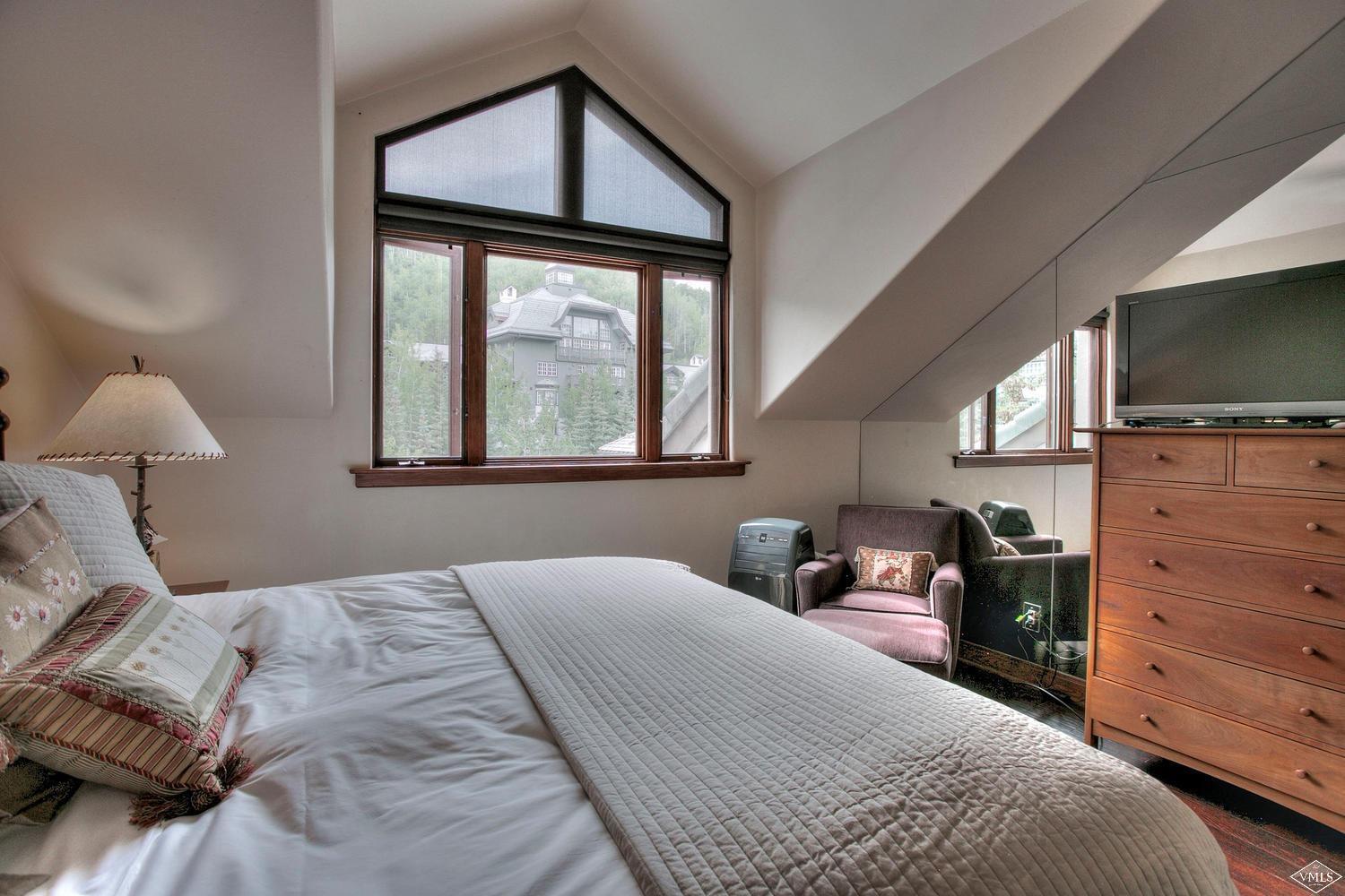 141 Scott Hill Road, Unit 402 Beaver Creek, CO 81620 - Photo 16 of 23 a bedroom with a bed and a flat tv screen on dresser