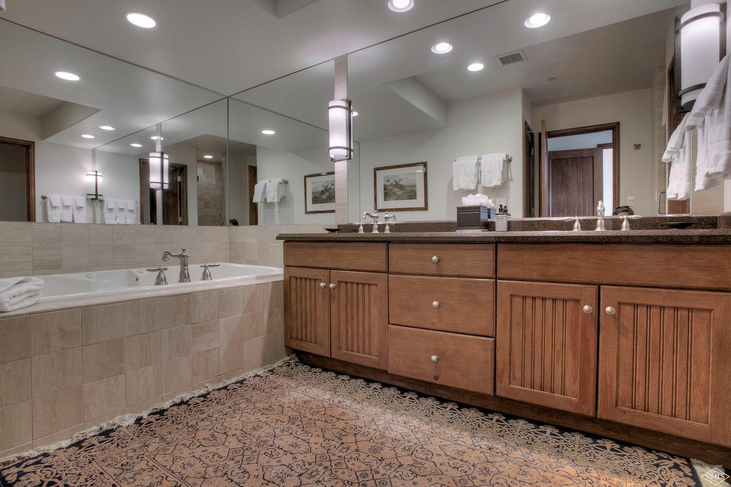 141 Scott Hill Road, Unit 402 Beaver Creek, CO 81620 - Photo 17 of 23 a large bathroom with double vanity sinks a vanity and a large mirror