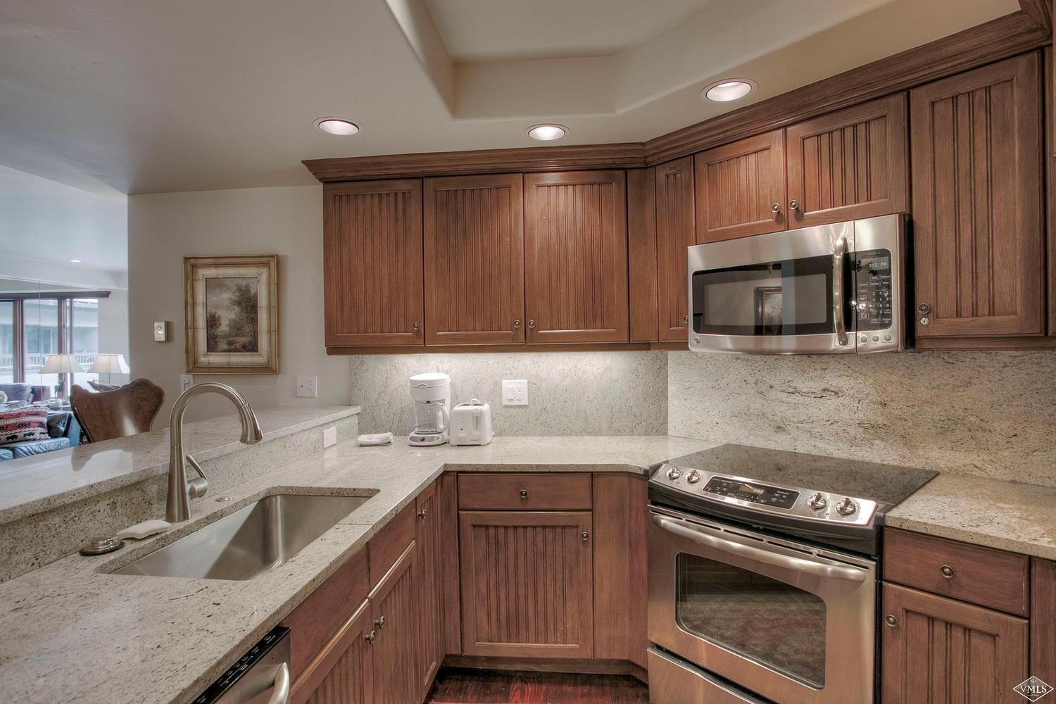 141 Scott Hill Road, Unit 402 Beaver Creek, CO 81620 - Photo 8 of 23 a kitchen with sink a microwave and cabinets