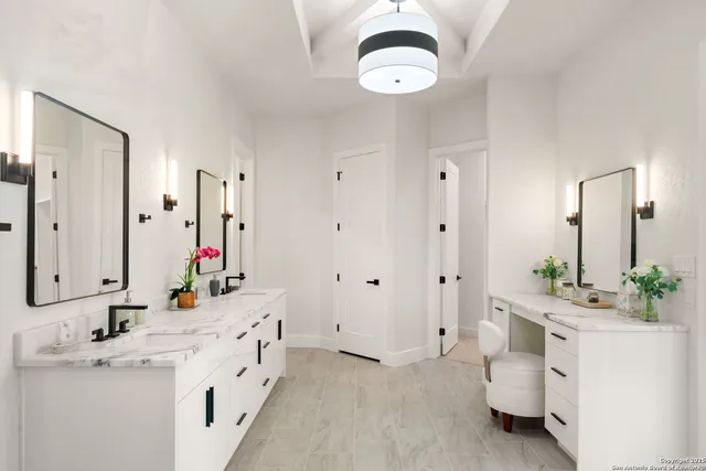 a spacious bathroom with double vanity a mirror a vanity and a shower