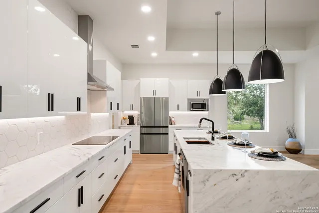a kitchen with stainless steel appliances kitchen island granite countertop a sink and a refrigerator