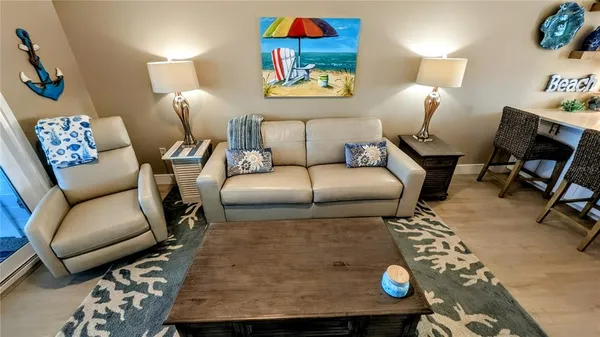 a living room with furniture and a view of kitchen