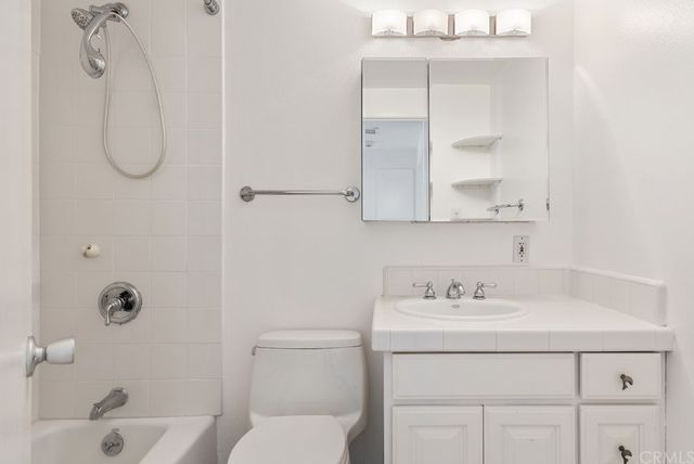 a bathroom with a sink vanity and a shower