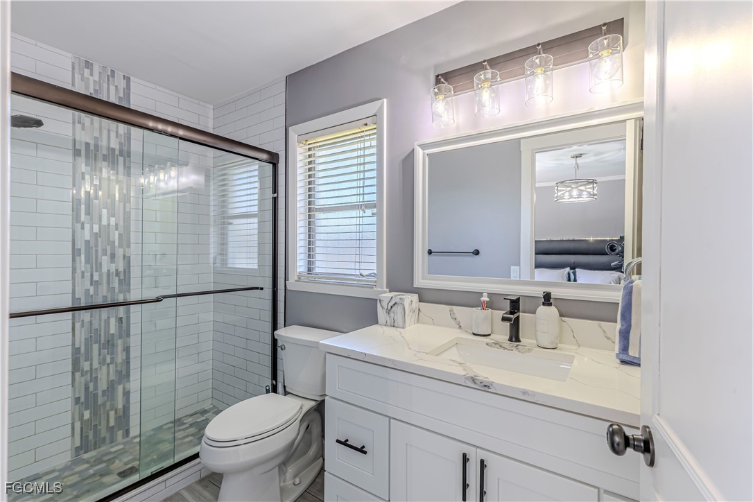 754 105th Avenue North Naples, FL 34108 - Photo 16 of 32 a bathroom with a sink a toilet a mirror and shower