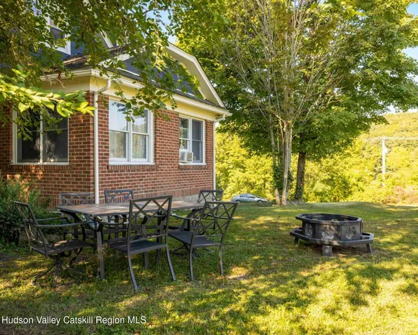 a backyard of a house with yard table and chairs