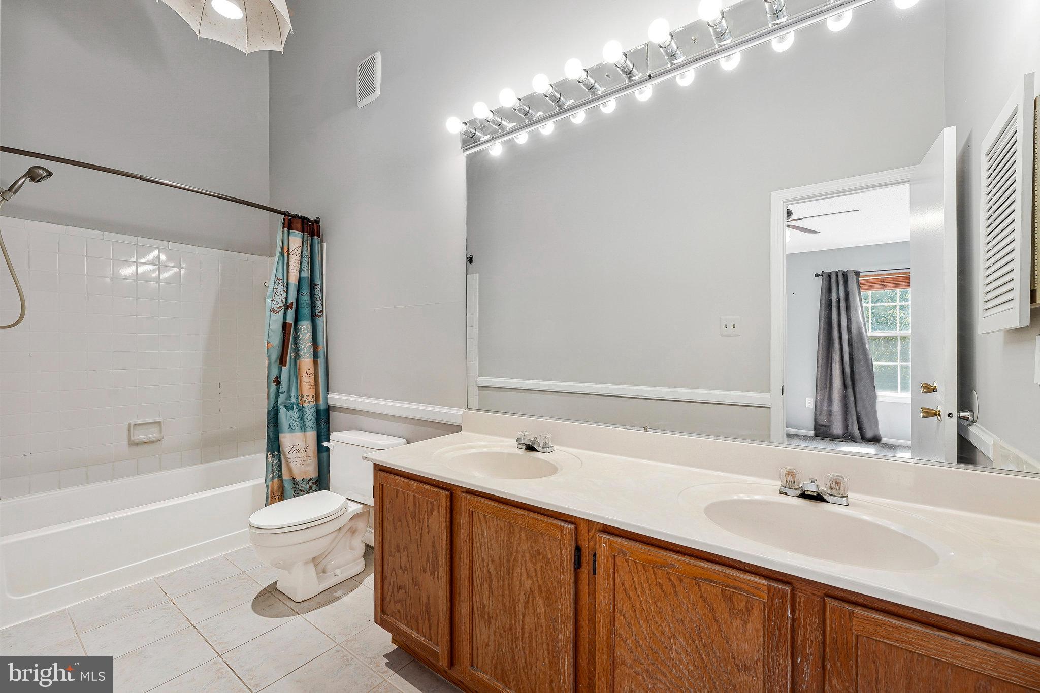 5803 Walden Commons Court Burke, VA 22015 - Photo 9 of 20 a bathroom with a double vanity sink toilet and shower