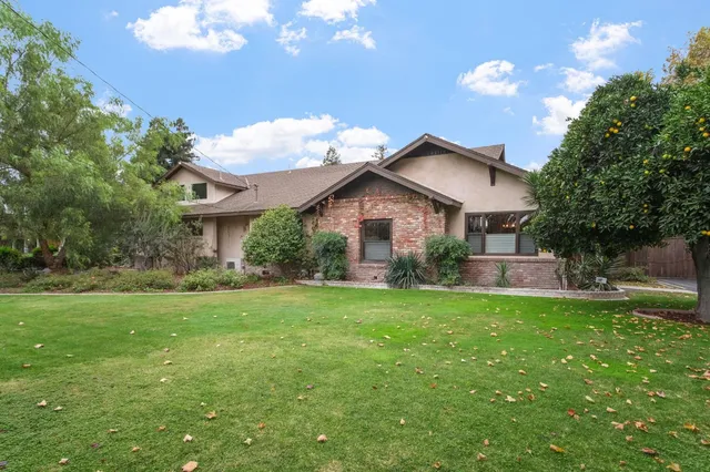 a front view of a house with a yard and trees