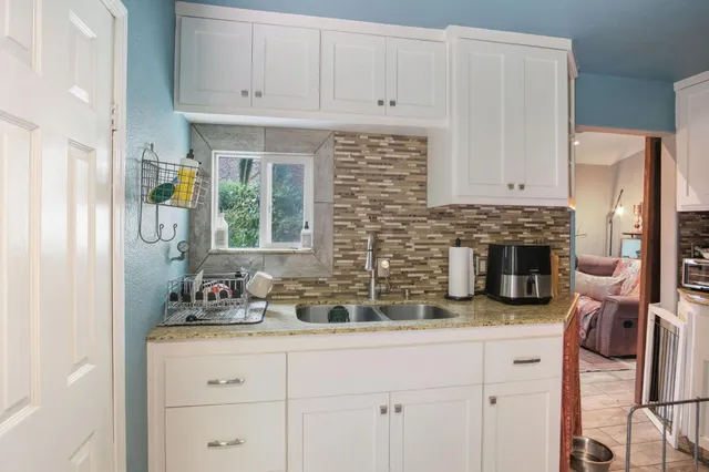 a view of a house with a yard and potted plants