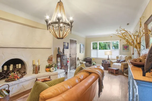 a living room with furniture a chandelier and a large window