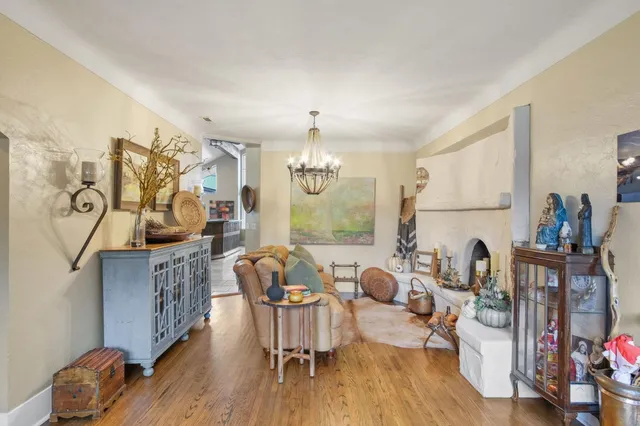 a living room with furniture a fireplace and a chandelier