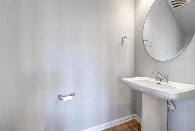 a view of empty room with wooden floor and window