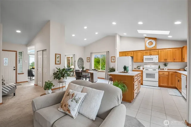 a living room with furniture kitchen and a large window
