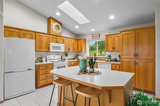 a kitchen with a table chairs refrigerator and cabinets