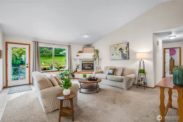 a living room with furniture a fireplace and a large window