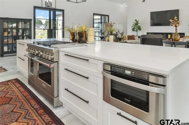 a kitchen with a stove and a white cabinets