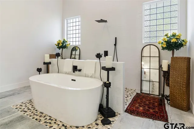 a white bath tub sitting next to a vanity