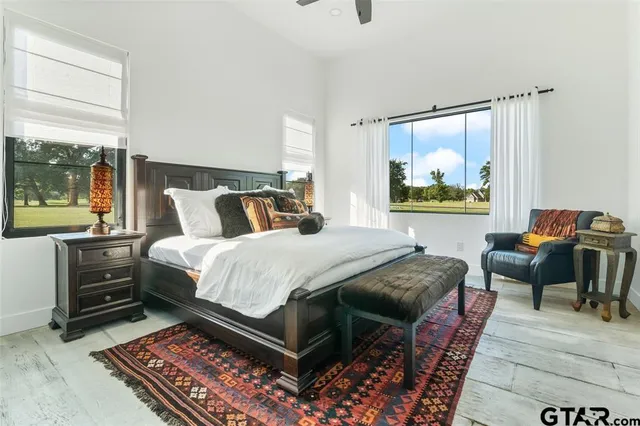 a bedroom with a bed and a dresser next to a window