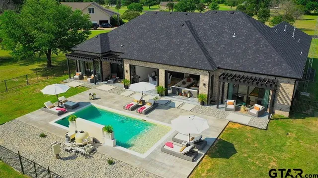 an aerial view of a house with swimming pool garden and lake view