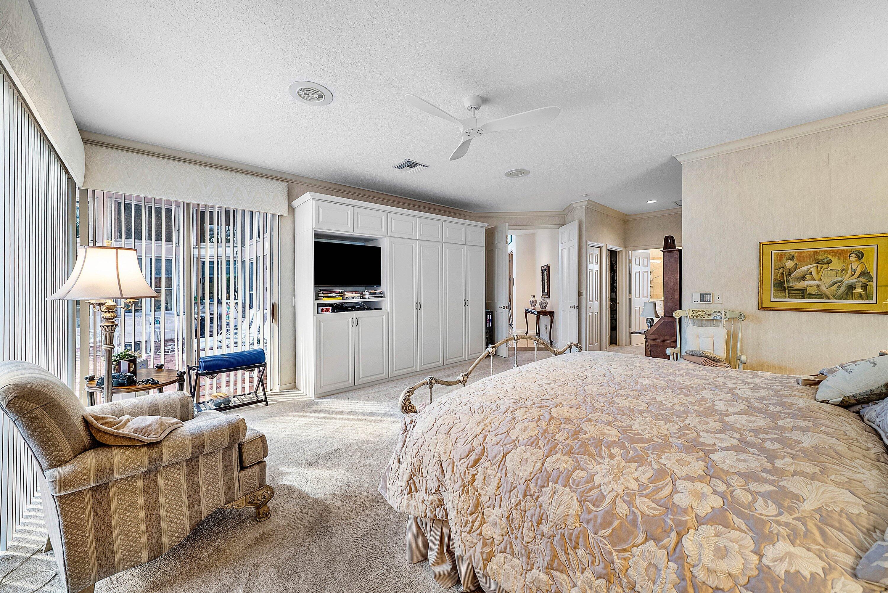 7142 Montrico Drive Boca Raton, FL 33433 - Photo 35 of 59 a spacious bedroom with a large bed flat screen tv and windows