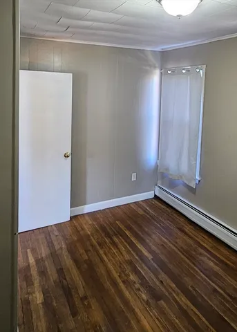 a view of room with window and wooden floor